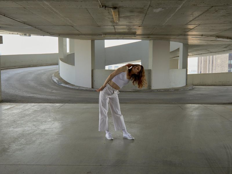 Person performing a dynamic yoga stretch in a modern, minimalist room.